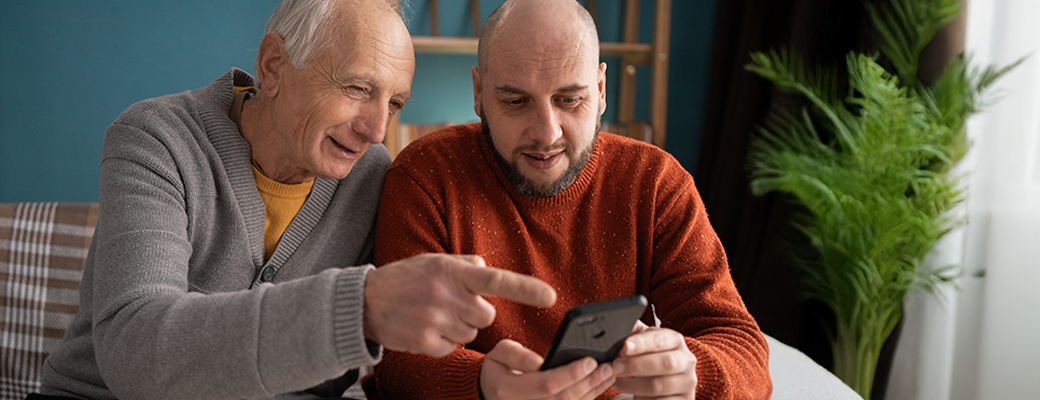 Image of senior man and his son looking at a smartphone